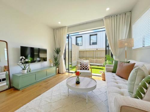 a living room with a couch and a table at Central Oasis Hideaway - Aircon 2-BR VS Backyard Close to Ponsonby in Auckland