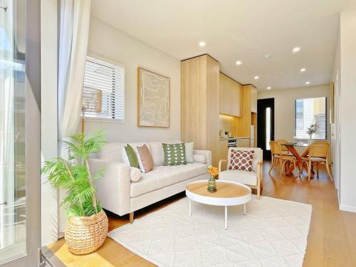 a living room with a couch and a table at Central Oasis Hideaway - Aircon 2-BR VS Backyard Close to Ponsonby in Auckland