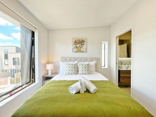 a bedroom with a large bed with towels on it at Central Oasis Hideaway - Aircon 2-BR VS Backyard Close to Ponsonby in Auckland