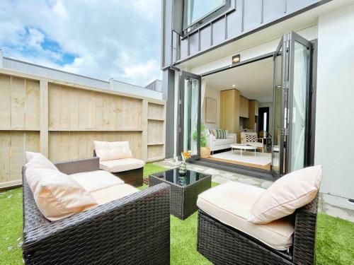 a patio with two wicker chairs and a table at Central Oasis Hideaway - Aircon 2-BR VS Backyard Close to Ponsonby in Auckland