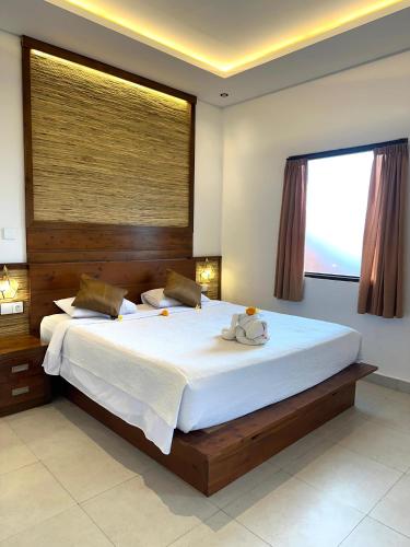 a bedroom with a large bed with a large window at Villa Karma Loka in Sidemen