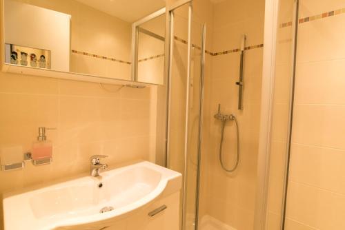 a bathroom with a sink and a glass shower at Haus Cristal - 1441m in Leukerbad