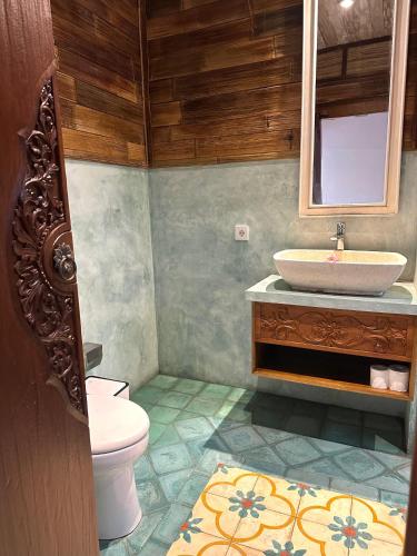 a bathroom with a sink and a toilet at Villa Karma Loka in Sidemen