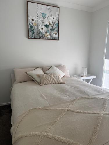 a bedroom with a bed with a picture on the wall at Tranquil Retreat - Your Own Room in a Peaceful Modern Shared House in Warner Lakes in Lawnton