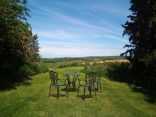 three chairs and a table in the grass at Domaine de Polf,ages - just for you and your family in Villautou