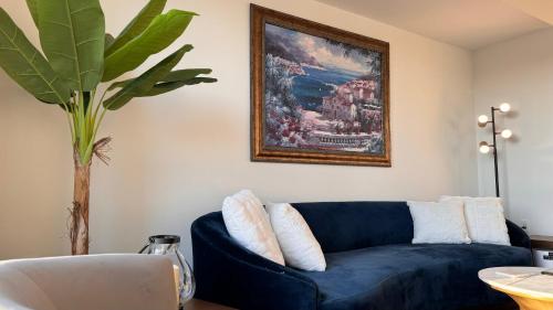 a blue couch in a living room with a painting at Wallace Luxurious in Los Angeles