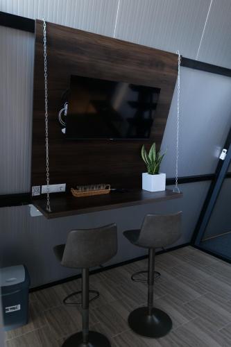 a room with two chairs and a table with a tv at Green Village Pensiune in Roşu