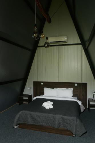 a bedroom with a large bed in a attic at Green Village Pensiune in Roşu
