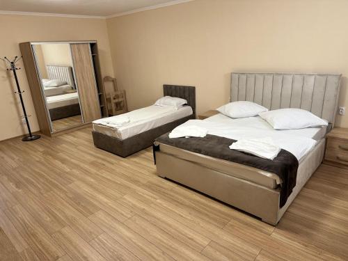 a bedroom with two beds and a large mirror at Pensiunea La Vasile in Zalău
