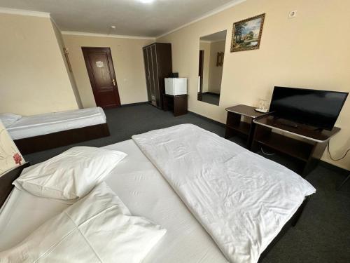 a hotel room with two beds and a television at Pensiunea La Vasile in Zalău