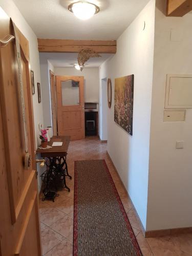 a hallway with a table and a room with a door at Hauspircher in Reith bei Seefeld
