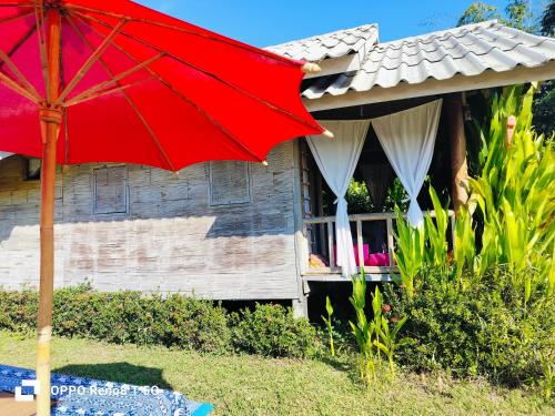 a red umbrella in front of a house at Tulip Resort Pai in Pai