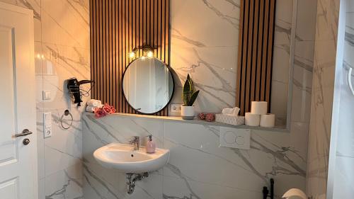 a bathroom with a sink and a mirror at RelaxDays-Apartments 2 GARTEN und POOL- Mitbenutzung, kostenloser Parkplatz, kontaktloser CheckIn, WiFi mit SmartTV in Gütersloh