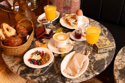a breakfast table with breakfast foods and orange juice at Hotel du Temps Madrid in Madrid