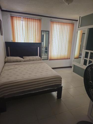a bedroom with a large bed and two windows at Casa en zona residencial in Oaxaca City