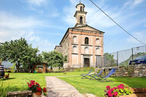 an old church with a clock tower in a yard at Il posto al sole in Teglio