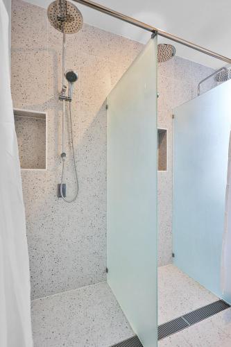 a shower with a glass door in a bathroom at Pad Hostel in Sydney