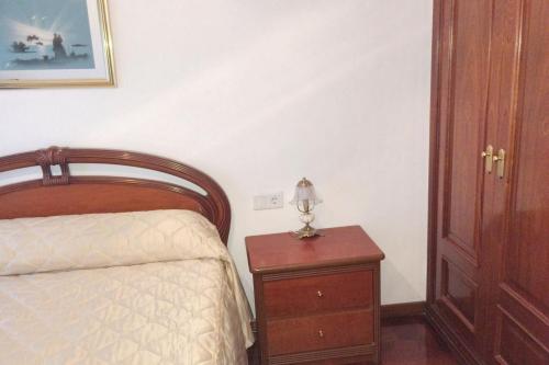 a bedroom with a bed and a table with a lamp at Charming Apartment in El Grove, Sea View in O Grove