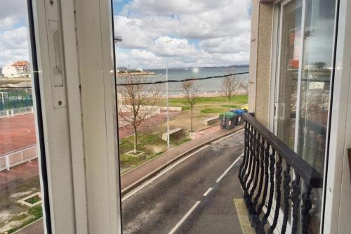 a window with a view of a road from a balcony at Charming Apartment in El Grove, Sea View in O Grove