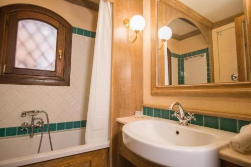 a bathroom with a sink and a tub and a mirror at Beautiful Il Giardino degli Oleandri one bedroom sleeps two num0850 in Liscia di Vacca