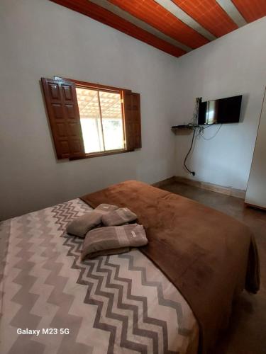 a bedroom with a large bed and a window at Cantinho do Ipê Alto Caparaó MG in Caparaó Velho