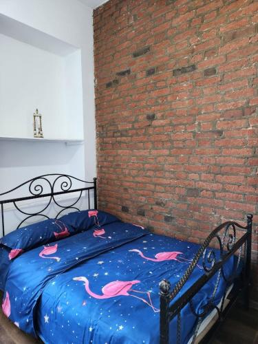 a bed in a room next to a brick wall at City Guli in Tbilisi City