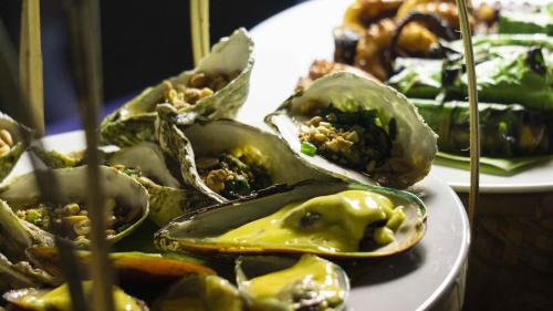 a plate of food with green peppers on a table at Seaside Boutique Resort Quy Nhon in Quy Nhon