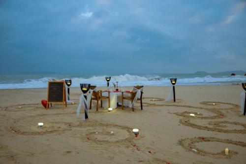 a table and chairs on the beach with the number at Seaside Boutique Resort Quy Nhon in Quy Nhon