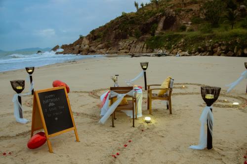 a table and chairs in the sand on a beach at Seaside Boutique Resort Quy Nhon in Quy Nhon
