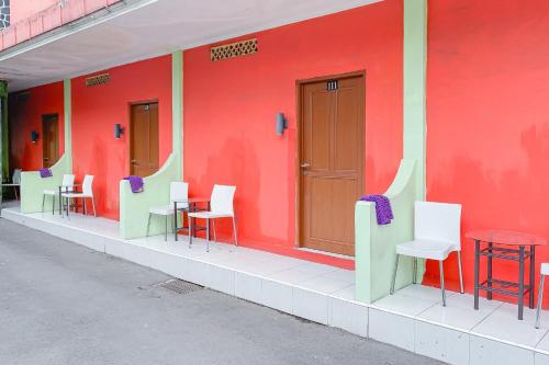 a building with colorful chairs and tables on the side of it at Urbanview Hotel Dasa Putra Syariah Sumedang in Parakankondang