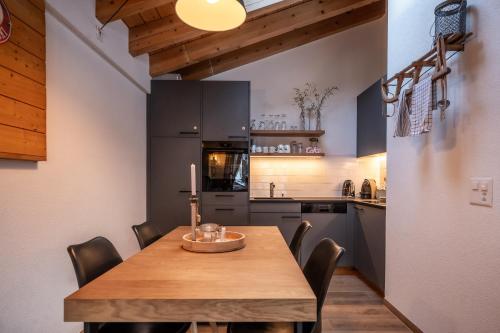 a kitchen with a wooden table and chairs at Dachwohnung Balma-great overview of Zermatt in Zermatt