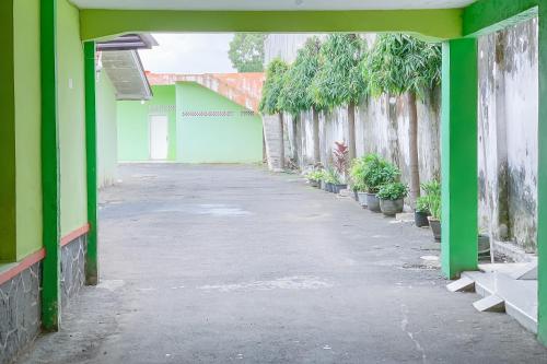 an empty hallway of a building with green walls and plants at Urbanview Hotel Dasa Putra Syariah Sumedang in Parakankondang