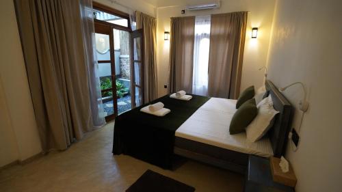 a bedroom with a bed with pillows and a window at OMA Hikkaduwa in Hikkaduwa