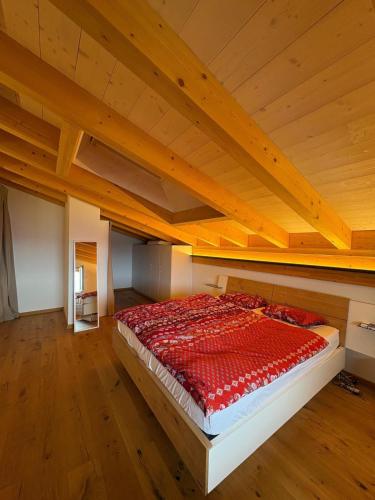 a large bed in a room with a wooden ceiling at Loft de luxe en attique avec vues panoramiques in Vionnaz