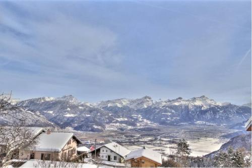 a snow covered town with mountains in the background at Loft de luxe en attique avec vues panoramiques in Vionnaz