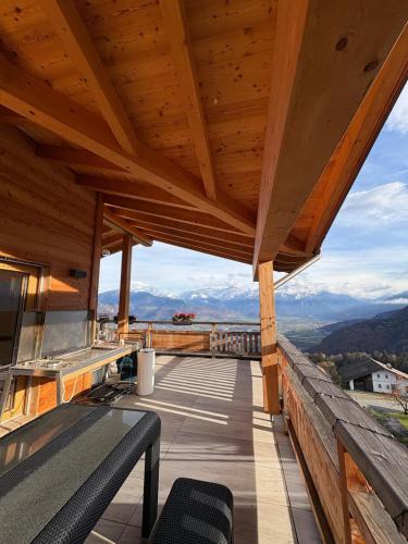 a wooden balcony with a view of the mountains at Loft de luxe en attique avec vues panoramiques in Vionnaz