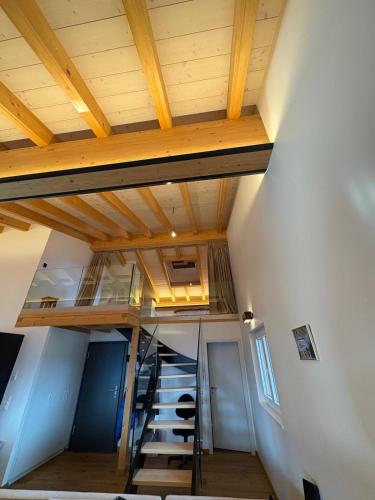 a staircase in a room with a wooden ceiling at Loft de luxe en attique avec vues panoramiques in Vionnaz