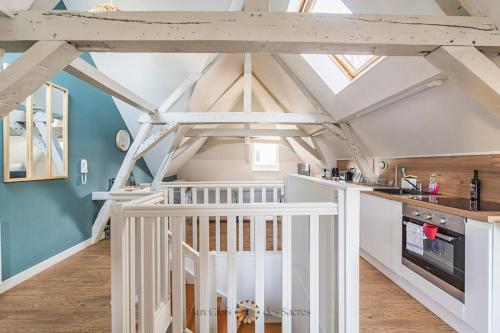 - une cuisine avec un plafond voûté et des placards blancs dans l'établissement 3 Chambres quartier cathedrale, à Reims