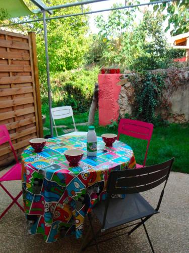 a table with a bottle of wine on top of it at Gite le 23 dans cite médiévale in Saint-Macaire