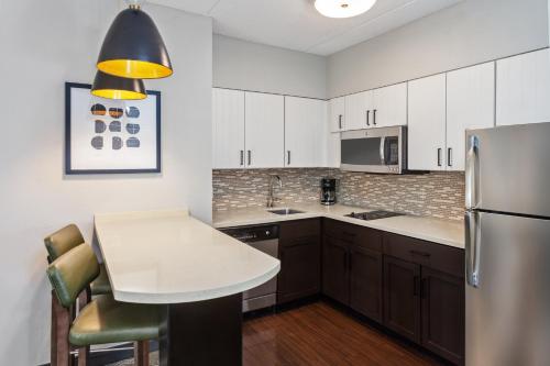 a kitchen with a table and a refrigerator at Staybridge Suites Albany Wolf Rd-Colonie Center by IHG in Albany