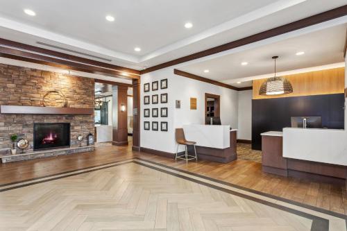 a living room with a fireplace and a bar at Staybridge Suites Albany Wolf Rd-Colonie Center by IHG in Albany