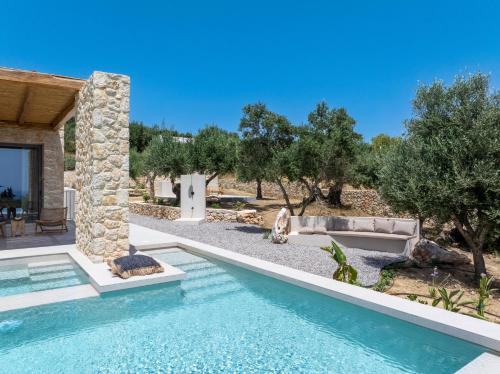 a swimming pool in a yard with a house at Lithos Art Villas in Sarlata
