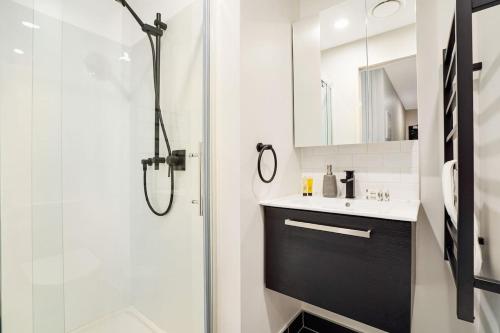 a bathroom with a shower and a sink at Cozy Aircon Studio Nearby Skytower - Pool Sauna Gym in Auckland
