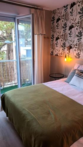 une chambre avec un grand lit et une grande fenêtre dans l'établissement Appartement Cosy proche plage, à Carnac