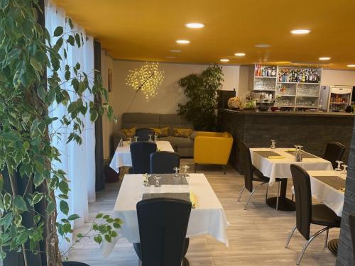 a restaurant with tables and chairs in a room at LOGIS Hôtel La Chaumière in Marseillan