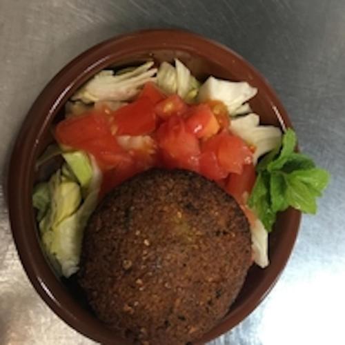 a bowl of salad with tomatoes and lettuce at LOGIS Hôtel La Chaumière in Marseillan