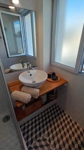 une salle de bain avec un lavabo et un miroir dans l'établissement Appartement Cosy proche plage, à Carnac