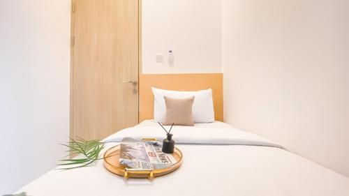 a bed with a tray with a newspaper on it at PIK 2 Tokyo Riverside 2 BEDROOM in Gedong