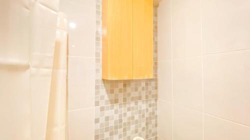 a bathroom with a shower with a yellow curtain at PIK 2 Tokyo Riverside 2 BEDROOM in Gedong