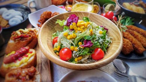 a table with a bowl of salad and other food at SARASA HOTEL Namba in Osaka